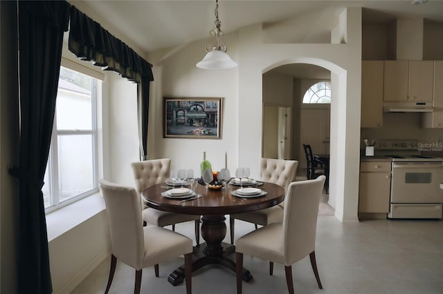 dining area with plenty of natural light, light tile floors, and lofted ceiling