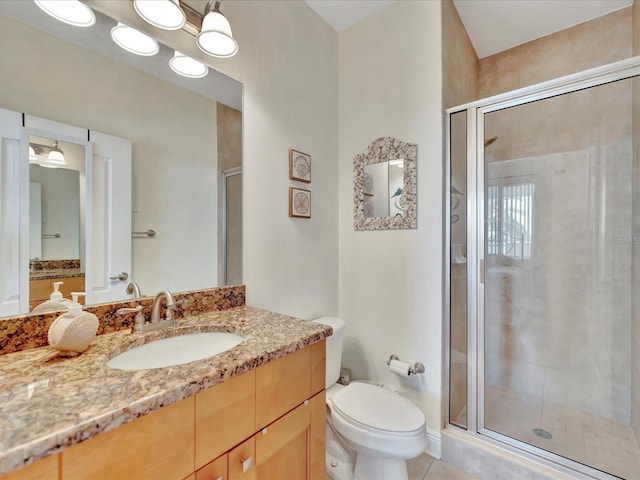 bathroom featuring toilet, a shower with door, tile floors, and vanity