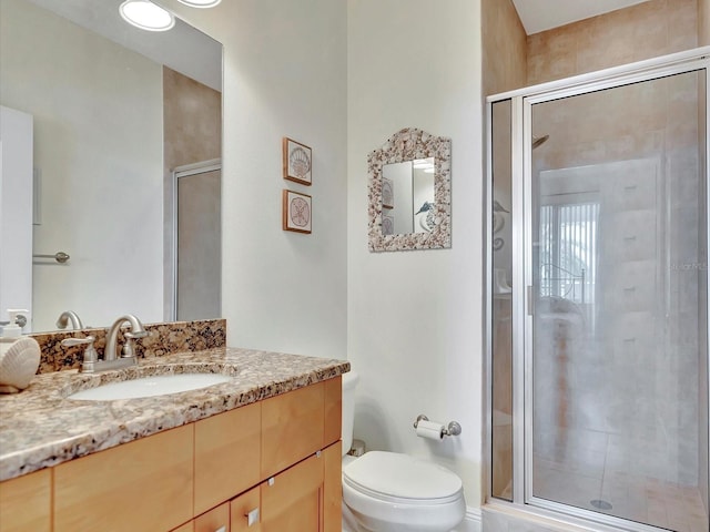 bathroom featuring walk in shower, toilet, and large vanity