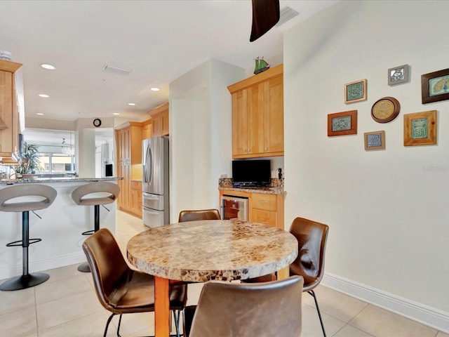 dining space featuring light tile floors and ceiling fan