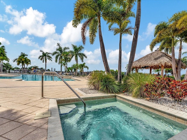 view of pool featuring a patio and a hot tub