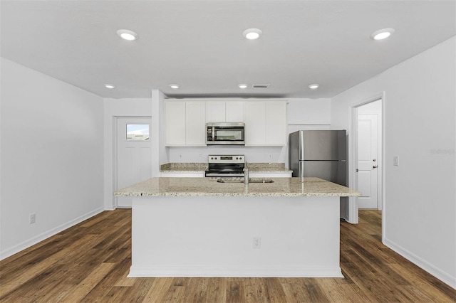 kitchen featuring dark hardwood / wood-style flooring, white cabinetry, appliances with stainless steel finishes, and light stone counters