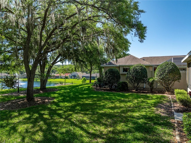 view of yard with a water view and fence