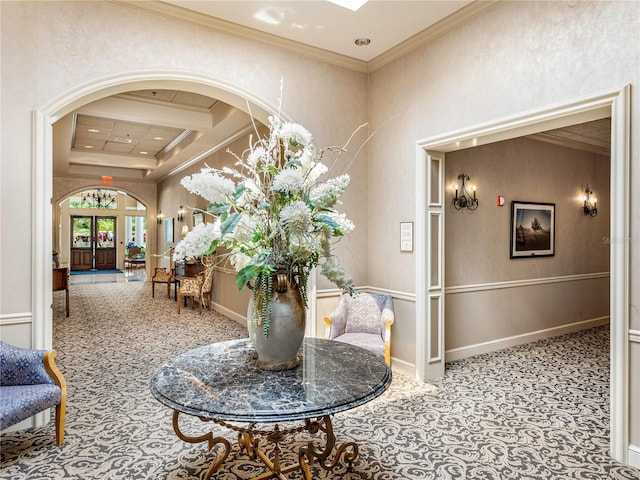 interior space featuring baseboards, arched walkways, coffered ceiling, crown molding, and french doors