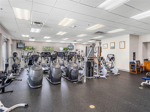 workout area featuring a drop ceiling, visible vents, and baseboards