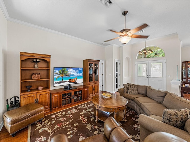 living area with french doors, wood finished floors, visible vents, and crown molding