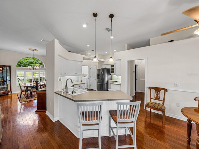 kitchen featuring a breakfast bar area, dark hardwood / wood-style floors, sink, white cabinets, and stainless steel refrigerator with ice dispenser