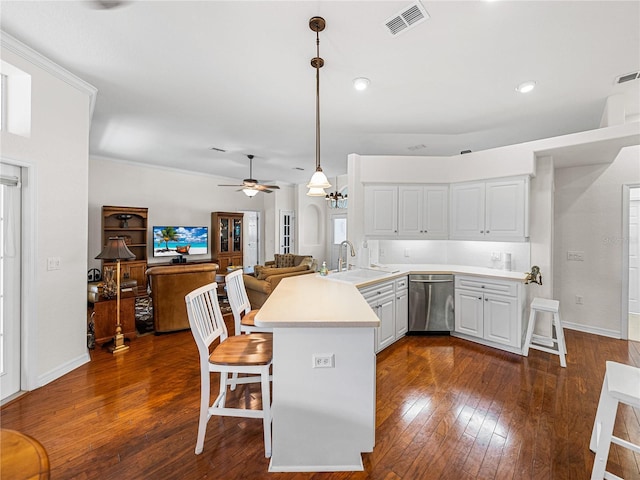 kitchen featuring a peninsula, a sink, light countertops, dishwasher, and pendant lighting