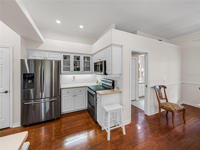 kitchen featuring appliances with stainless steel finishes, backsplash, and dark hardwood / wood-style flooring