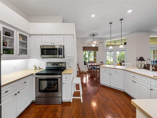 kitchen featuring light countertops, appliances with stainless steel finishes, glass insert cabinets, and white cabinetry