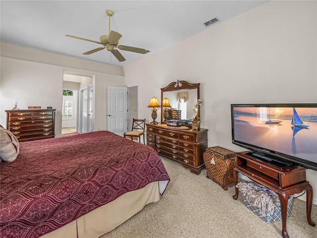 bedroom featuring a ceiling fan, visible vents, and light colored carpet