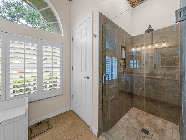 full bathroom featuring a stall shower, tile patterned flooring, and baseboards