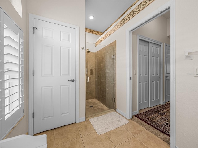 bathroom with a shower stall, baseboards, and tile patterned floors