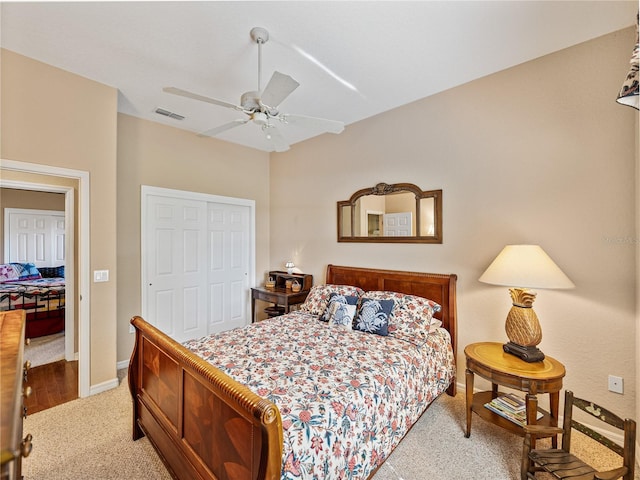 bedroom featuring light carpet, visible vents, baseboards, ceiling fan, and a closet