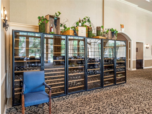 wine room with ornamental molding, arched walkways, and a towering ceiling