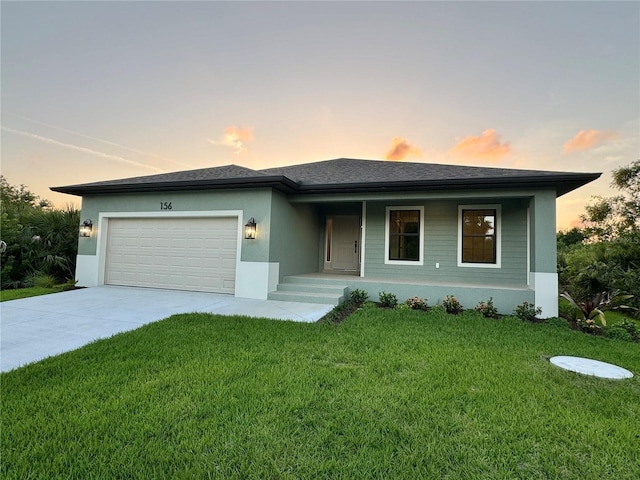 view of front of house with a garage and a yard