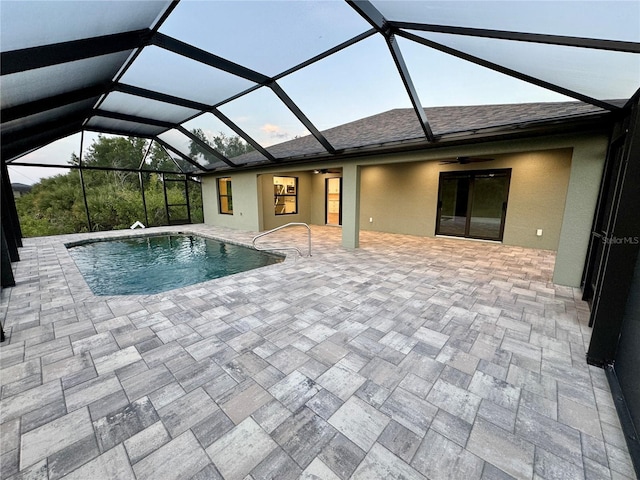 view of pool with glass enclosure, ceiling fan, and a patio