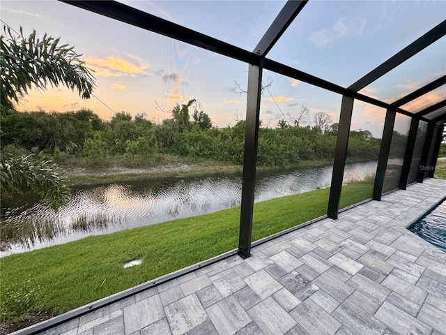 unfurnished sunroom featuring a water view