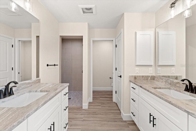 bathroom featuring vanity, tiled shower, and hardwood / wood-style floors