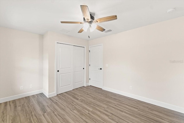 unfurnished bedroom featuring ceiling fan, a closet, and light hardwood / wood-style flooring