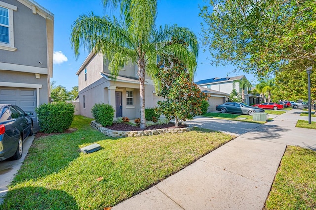 traditional home featuring a garage, driveway, a front lawn, and stucco siding