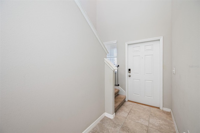 doorway featuring stairway, baseboards, and light tile patterned floors