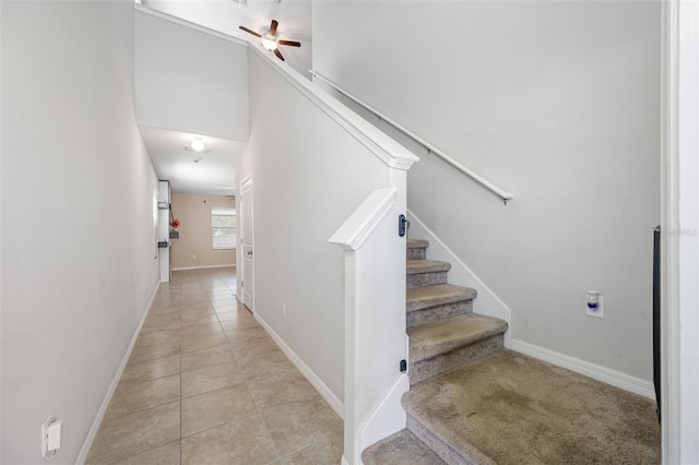 stairway featuring baseboards, a ceiling fan, and tile patterned floors