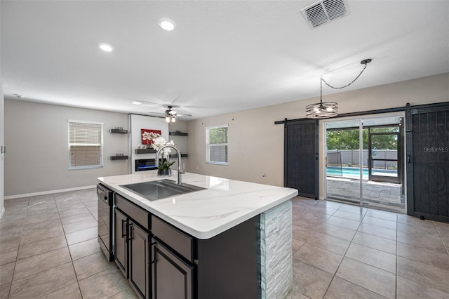 kitchen with black dishwasher, a barn door, visible vents, a ceiling fan, and a sink