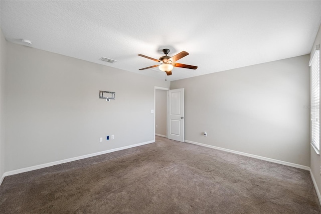 carpeted spare room with a ceiling fan, baseboards, visible vents, and a textured ceiling