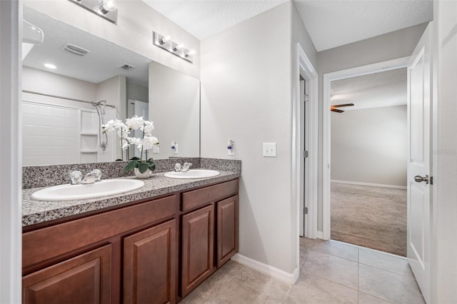 bathroom with visible vents, a sink, a textured ceiling, and walk in shower