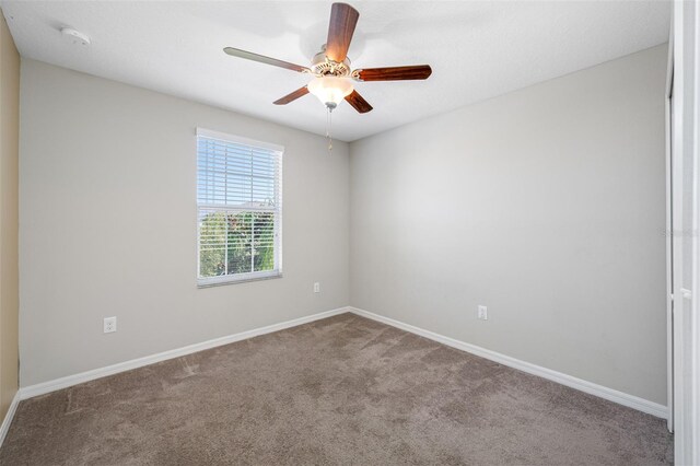 empty room with ceiling fan, baseboards, and carpet flooring