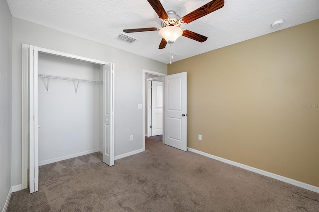 unfurnished bedroom with carpet, a closet, visible vents, a textured ceiling, and baseboards