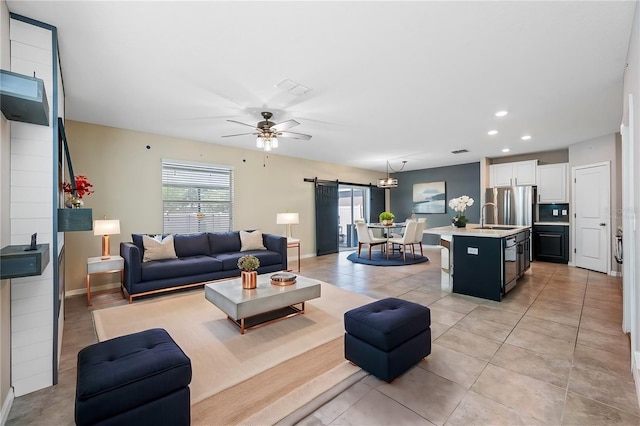 living room with light tile patterned floors, a barn door, recessed lighting, a ceiling fan, and baseboards