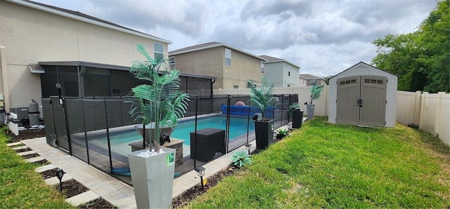 view of pool with a fenced backyard, an outdoor structure, a yard, a fenced in pool, and a storage unit