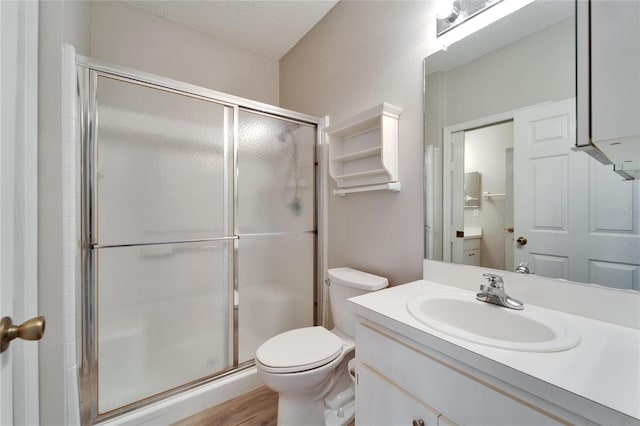 bathroom with toilet, a textured ceiling, hardwood / wood-style flooring, vanity, and a shower with door