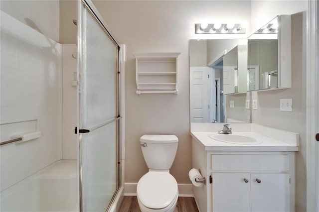 bathroom with vanity, toilet, hardwood / wood-style floors, and a shower with door