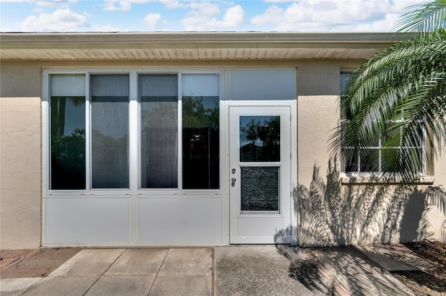 view of exterior entry with a patio area