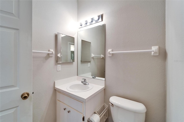 bathroom featuring toilet and vanity