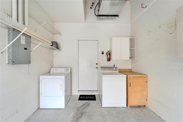 laundry area with cabinets, electric panel, and washer and clothes dryer