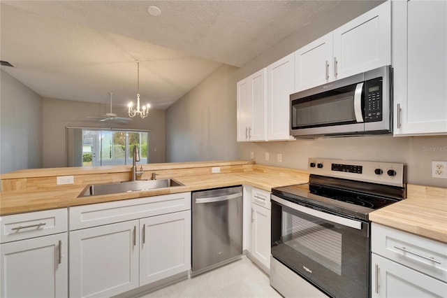 kitchen featuring sink, white cabinetry, butcher block counters, and stainless steel appliances