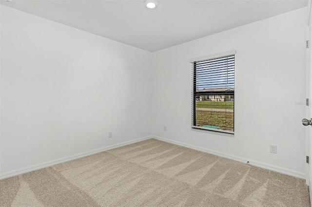 unfurnished room featuring light colored carpet