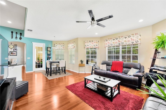 living room with ceiling fan and light hardwood / wood-style floors