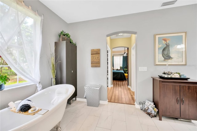 bathroom with a tub and tile floors