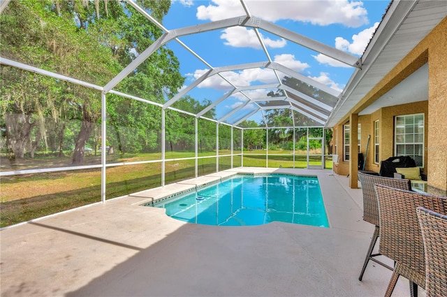 view of pool with a lanai, a lawn, and a patio