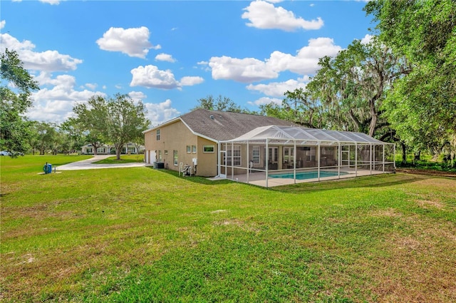 back of property with a patio area, a lanai, and a yard