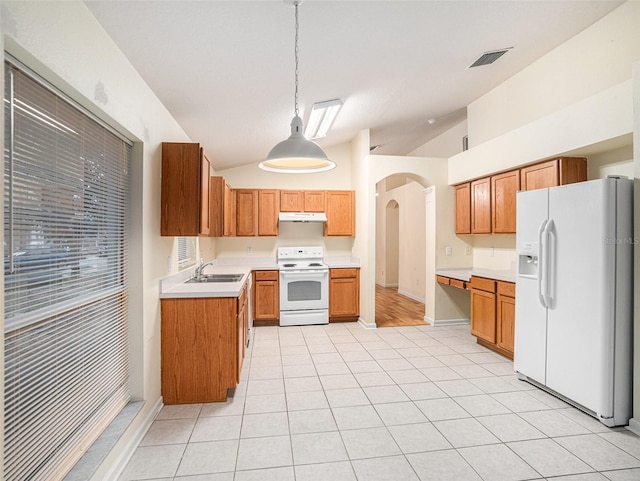 kitchen featuring white appliances, light hardwood / wood-style flooring, sink, hanging light fixtures, and vaulted ceiling