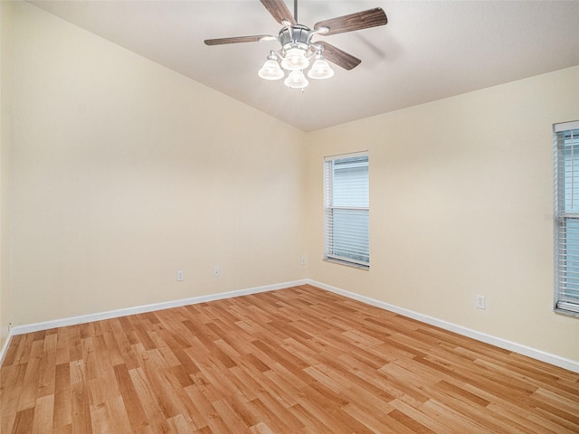 empty room featuring a ceiling fan, baseboards, and light wood finished floors