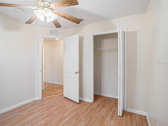 unfurnished bedroom featuring light wood finished floors, a closet, visible vents, and baseboards