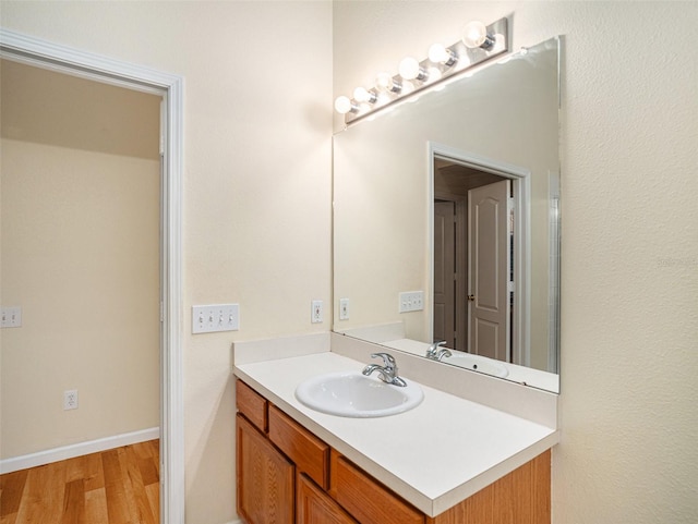 bathroom featuring wood finished floors, vanity, and baseboards