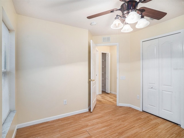 unfurnished bedroom featuring ceiling fan, a closet, and light wood-type flooring